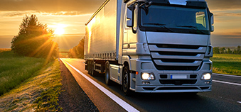 Ein Lastwagen fährt auf einer Straße im Sonnenschein